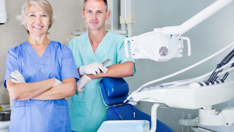Two,Professional,Confident,Dentists,Posing,Near,Dental,Chair,In,The
